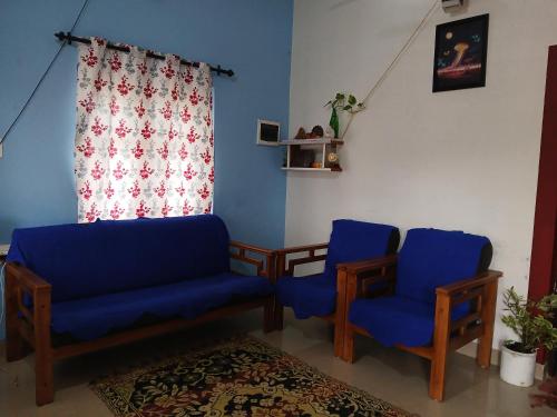 salon z 2 niebieskimi krzesłami i oknem w obiekcie Magic Wind homestay w mieście Alappuzha