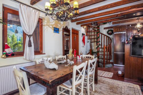 uma sala de jantar com uma mesa de madeira e cadeiras em Livadi cozy villa em Arachova