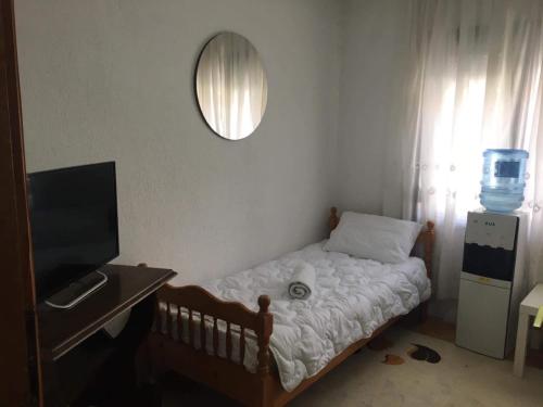 ein kleines Schlafzimmer mit einem Bett und einem Spiegel in der Unterkunft Rooms Struga in Struga