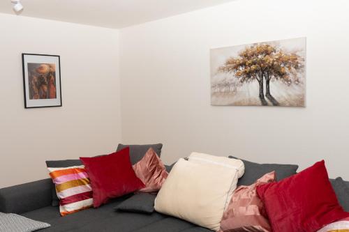 a living room with a couch with pillows and a tree at Taros Home - Deluxe Apartment in Herrenberg