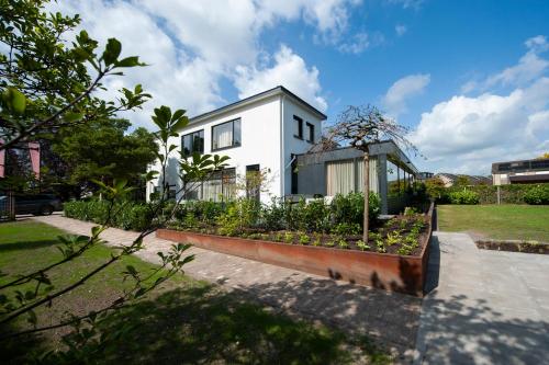 een wit huis met een tuin ervoor bij Boutique Hotel Villa Elise in Winterswijk