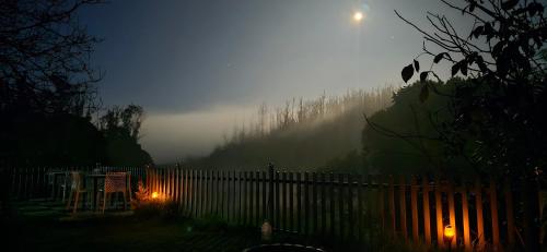 una noche de niebla con una valla en un patio en RR Forest View, en Ooty