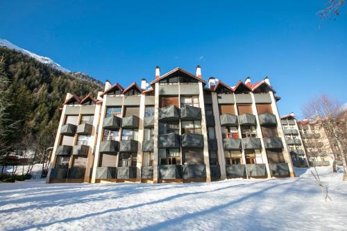 un edificio nella neve di fronte a una montagna di Résidence Grand Roc - Campanules 415 - Happy Rentals a Chamonix-Mont-Blanc