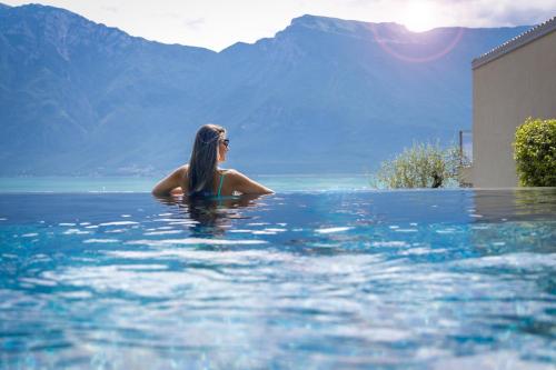 una donna seduta in acqua in piscina di LLAC Living Nature Hotel a Limone sul Garda