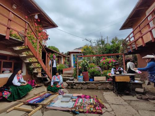 un groupe de personnes assises dans la cour d'un bâtiment dans l'établissement kaypi rosas wasi Amantani, à Ocosuyo