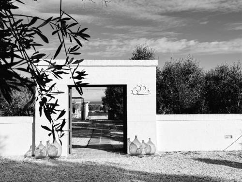 una foto in bianco e nero di un edificio con vasi di Tenuta Amostuni-Country House a Ostuni