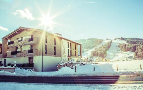 ein Gebäude an einer Skipiste mit der Sonne dahinter in der Unterkunft Enjoy The Alps in Flachau