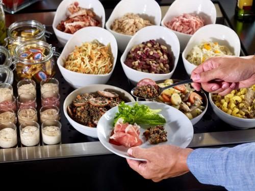 un buffet avec des bols de différents types de nourriture dans l'établissement Campanile Toulouse Sud-Labège innopole, à Labège