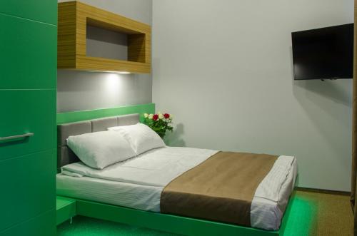 um quarto com uma cama com uma parede verde em Pushkinskaya Apartments em Carcóvia