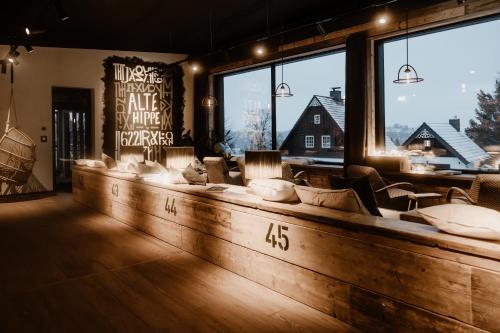 un bar con sofás y una gran ventana en THE HEARTS HOTEL - dein Boutique- und Event-Resort, en Braunlage