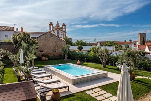 un cortile con piscina, sedie e un edificio di Villa Alter ad Alter do Chão