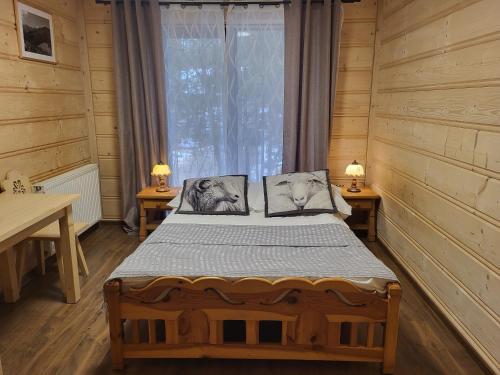 a bedroom with a bed in a log cabin at Pokoje Pod Lasem in Kościelisko