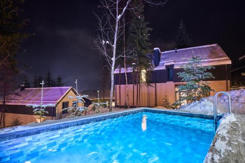 a swimming pool in the snow at night at Buko Village by Fomich in Bukovel