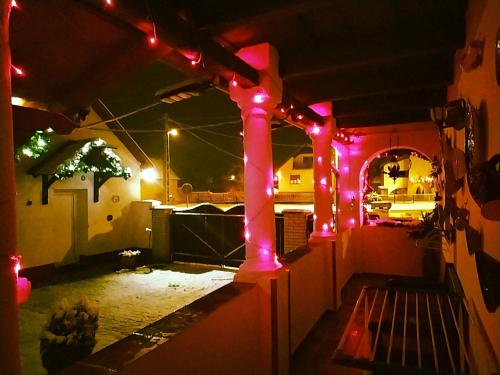 a patio lit up at night with red lights at Harmony Vendégház Egerszalók in Egerszalók