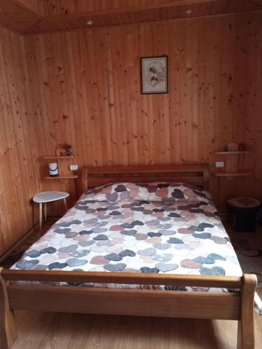 una camera da letto con letto in una camera in legno di Карпатські ночі Чан на території a Jaremče