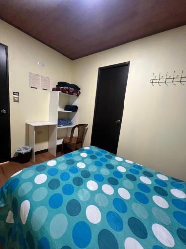 una camera con letto e coperta a pois di C&M Exclusive Private Rooms a Quetzaltenango