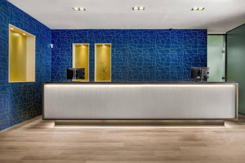 eine Lobby mit blauen Fliesen und eine Rezeption in der Unterkunft AC Hotel Tarragona by Marriott in Tarragona