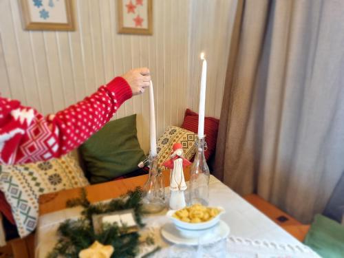 uma pessoa está pegando uma vela em uma mesa em Miodowa Chata em Comuna de Łapsze Niżne