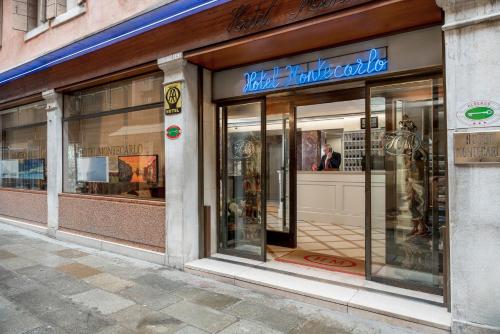 une façade de magasin avec portes vitrées dans une rue dans l'établissement Hotel Montecarlo, à Venise