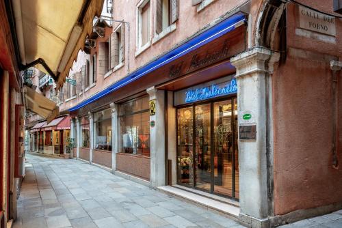 une rue vide avec un magasin sur le côté d'un bâtiment dans l'établissement Hotel Montecarlo, à Venise