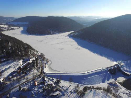 una vista aerea di un fiume con neve e alberi di Hotel Solina Resort & Spa a Solina