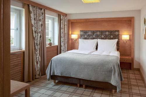 - une chambre avec un grand lit et 2 fenêtres dans l'établissement Wellness- & Sporthotel Jagdhof, à Röhrnbach