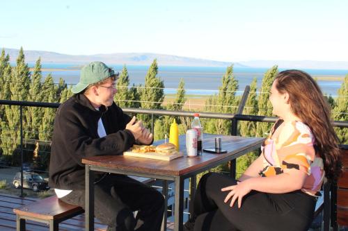 Ein Mann und eine Frau sitzen an einem Tisch in der Unterkunft Viajero Calafate Hostel in El Calafate