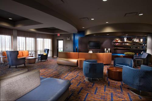 a lobby with a waiting room with chairs and tables at Courtyard by Marriott Fayetteville in Fayetteville