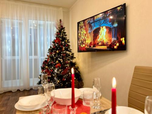 Un arbre de Noël dans une salle à manger avec une table dans l'établissement Апартаменты возле БЦ Тетрис Клочковская, à Kharkov