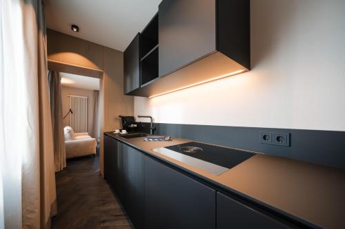 a kitchen with a sink and a counter top at Schwarzer Adler - Concept Living in Vipiteno