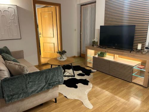 a living room with a couch and a flat screen tv at Schönes Wohnen am Wolfgangsee in Sankt Gilgen