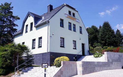 un edificio blanco con un cartel. en Apartments - Lehmanns Ferienwohnungen, en Kurort Oberwiesenthal