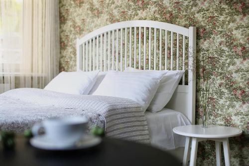 1 dormitorio con cama blanca y pared de flores en Pas Juste, en Nida