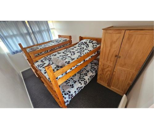 1 Schlafzimmer mit 2 Etagenbetten und einem Holzschrank in der Unterkunft High View Family Cottages in Warrnambool