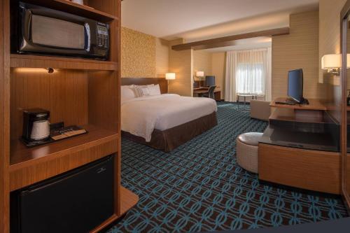 a hotel room with a bed and a flat screen tv at Fairfield Inn & Suites by Marriott Altoona in Altoona