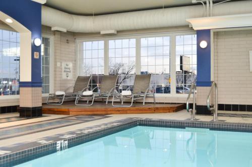 uma piscina com cadeiras e uma piscina em Amenida Residences, Calgary em Calgary