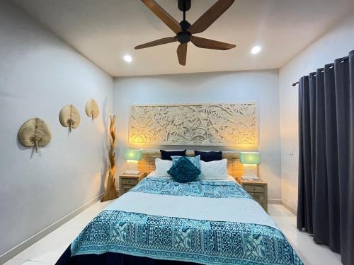 a bedroom with a bed and a ceiling fan at Bali Santi Bungalows in Candidasa