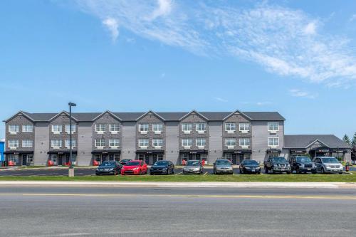 ein großes Gebäude mit Autos auf einem Parkplatz in der Unterkunft Quality Inn & Suites Amsterdam in Fredericton