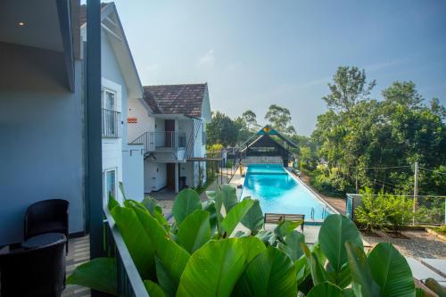 vistas a la piscina desde el balcón de una casa en Vbrings Oak Village, en Munnar