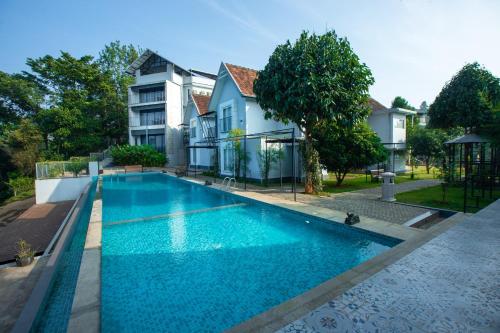 una piscina frente a una casa en Vbrings Oak Village, en Munnar