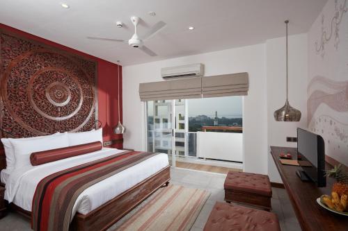 a bedroom with a king sized bed and a television at Jetwing Jaffna in Jaffna