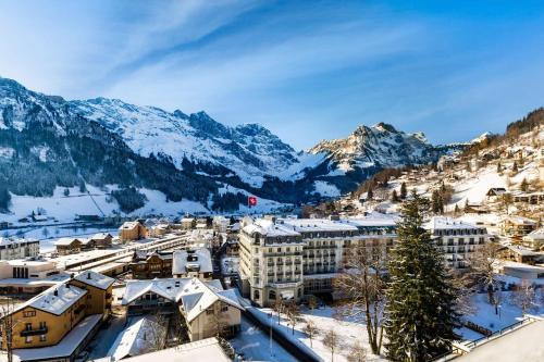 Kempinski Palace Engelberg في إنغيلبرغ: مدينة فيها جبال مغطاة بالثلج في الخلفية