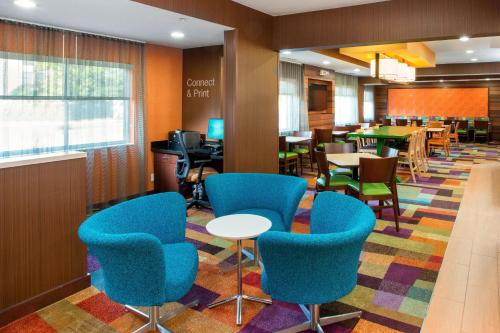 una sala de espera con sillas y mesas azules y una cafetería en Fairfield Inn & Suites Chicago Tinley Park, en Tinley Park