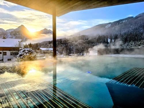 uma banheira de hidromassagem com vista para uma montanha de neve em Hotel Lärchenhof em Lermoos