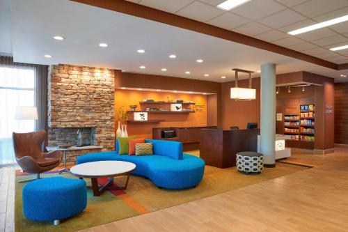 een lobby van een bibliotheek met blauwe meubels en een open haard bij Fairfield by Marriott Niagara Falls in Niagara Falls