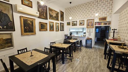 a restaurant with tables and chairs and pictures on the wall at Neferprod Apartments - IS - CAM 02 in Timişoara