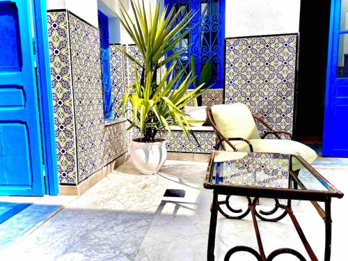 a room with a chair and a table and a plant at Dar Saida in Sidi Bou Saïd