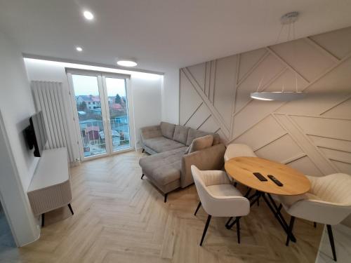 een woonkamer met een tafel en een bank bij Apartament KOŚCIUSZKI in Olecko