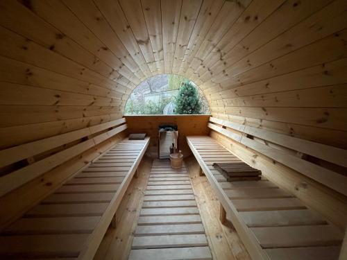 - un sauna avec bancs dans une pièce en bois dotée d'une fenêtre dans l'établissement Montaz Suite and Sauna, à Valtournenche