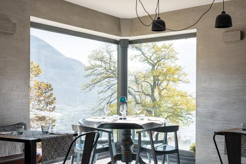 een eetkamer met een tafel en een groot raam bij Hotel Trento Alta 